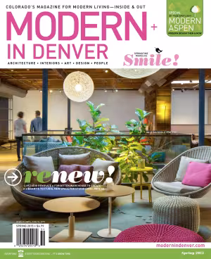Modern living room with vibrant furniture and large plants in a magazine cover photo.