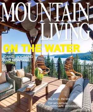 Outdoor patio with wicker chairs overlooking a lake and forest.