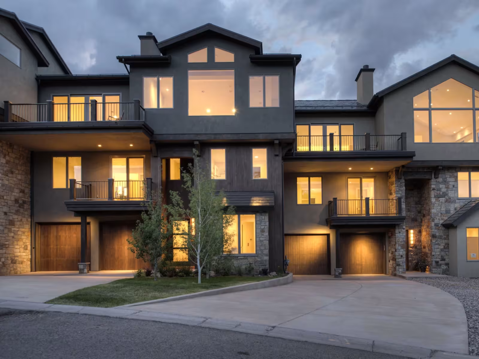Modern house with large lit windows at dusk.