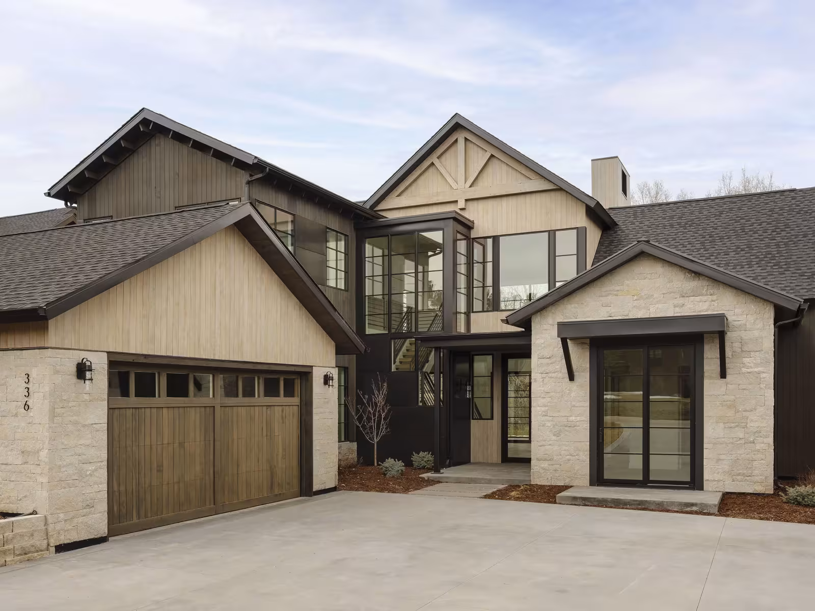 Contemporary two-storey house with stone and wood façade.