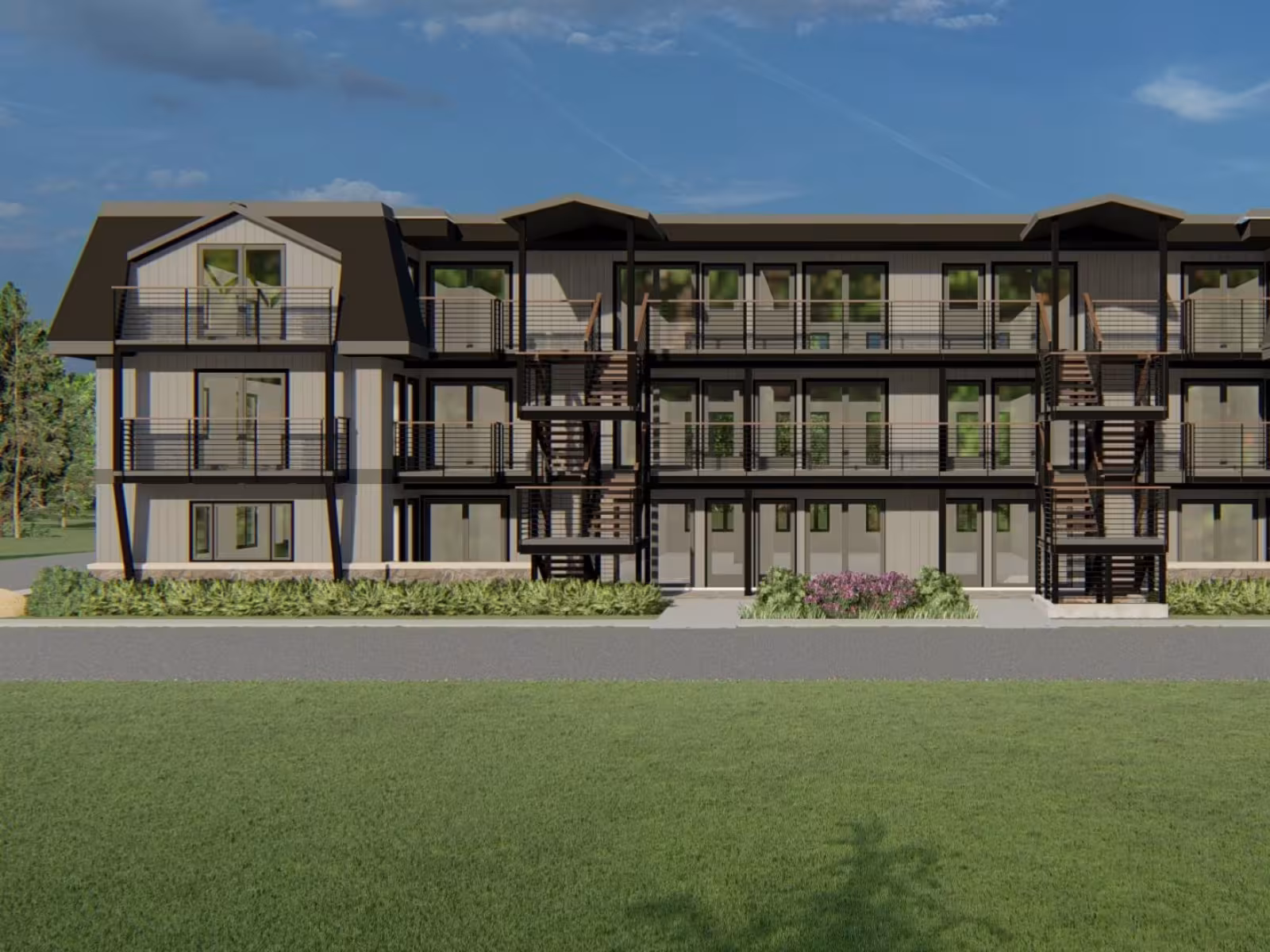 Three-storey apartment building with balconies, set against a blue sky and surrounded by grass.