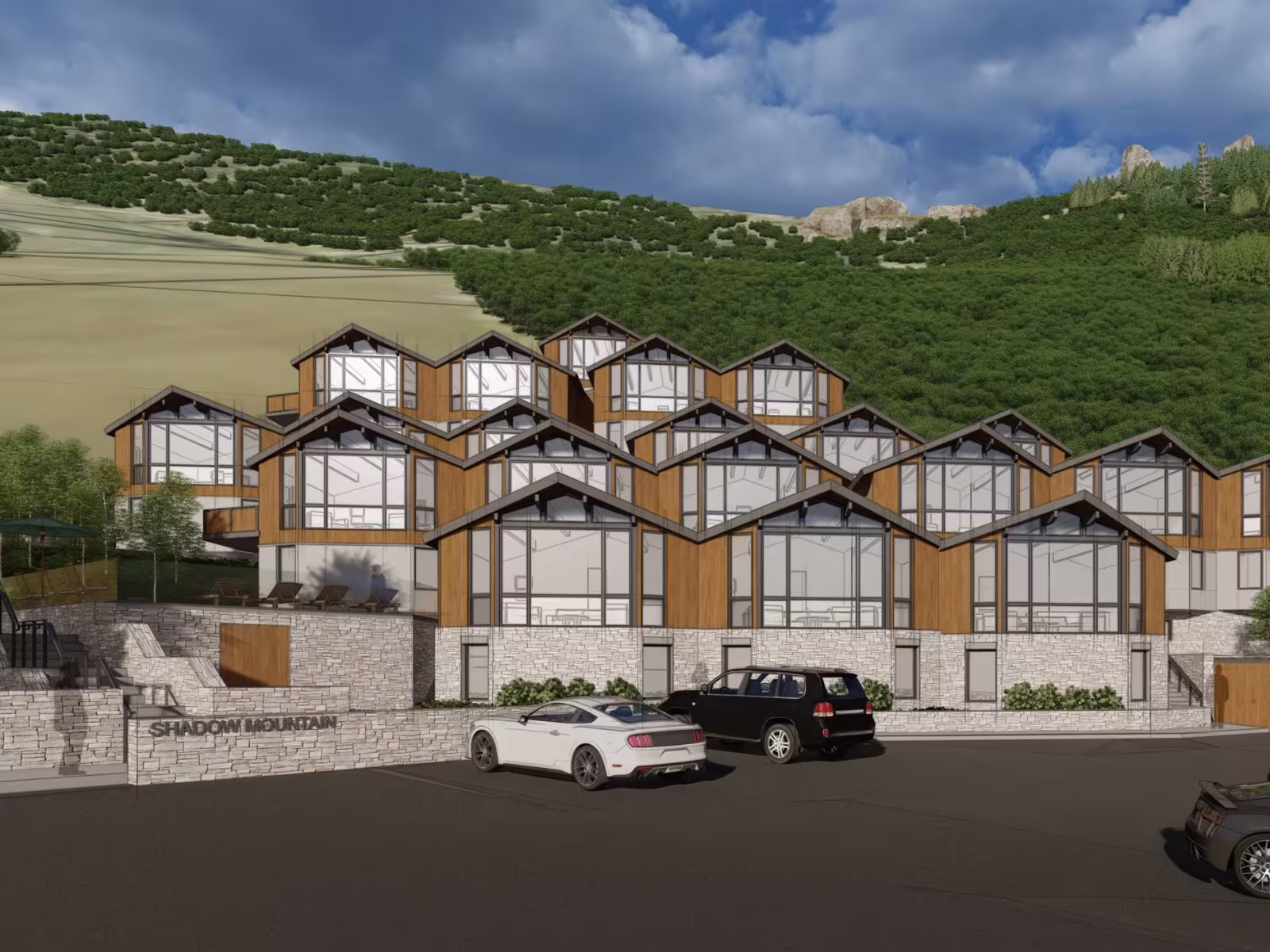 Alpine-style buildings with parked cars, set against a wooded hillside.