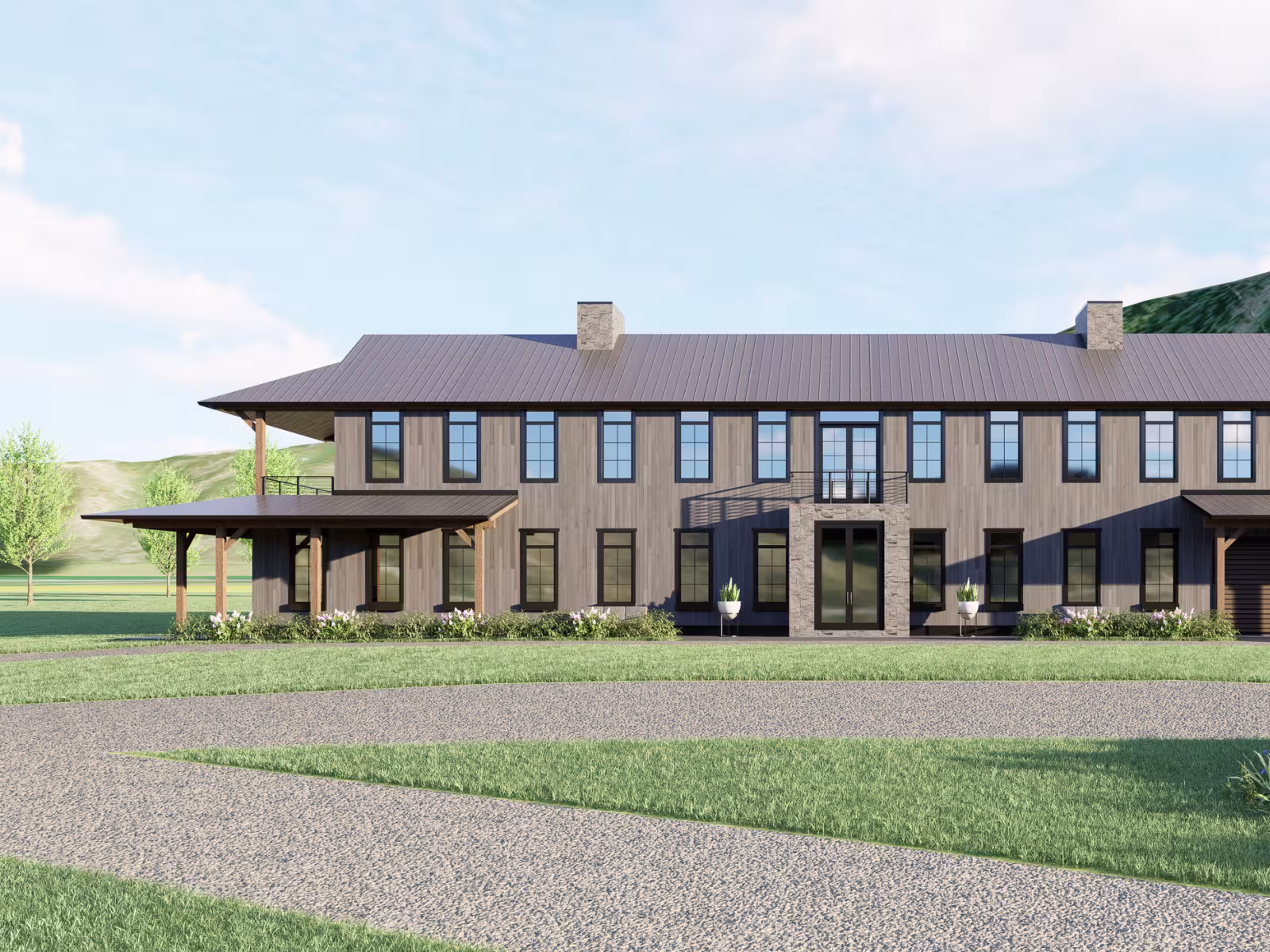 Large modern farmhouse with a porch, set in a green landscape under a cloudy sky.