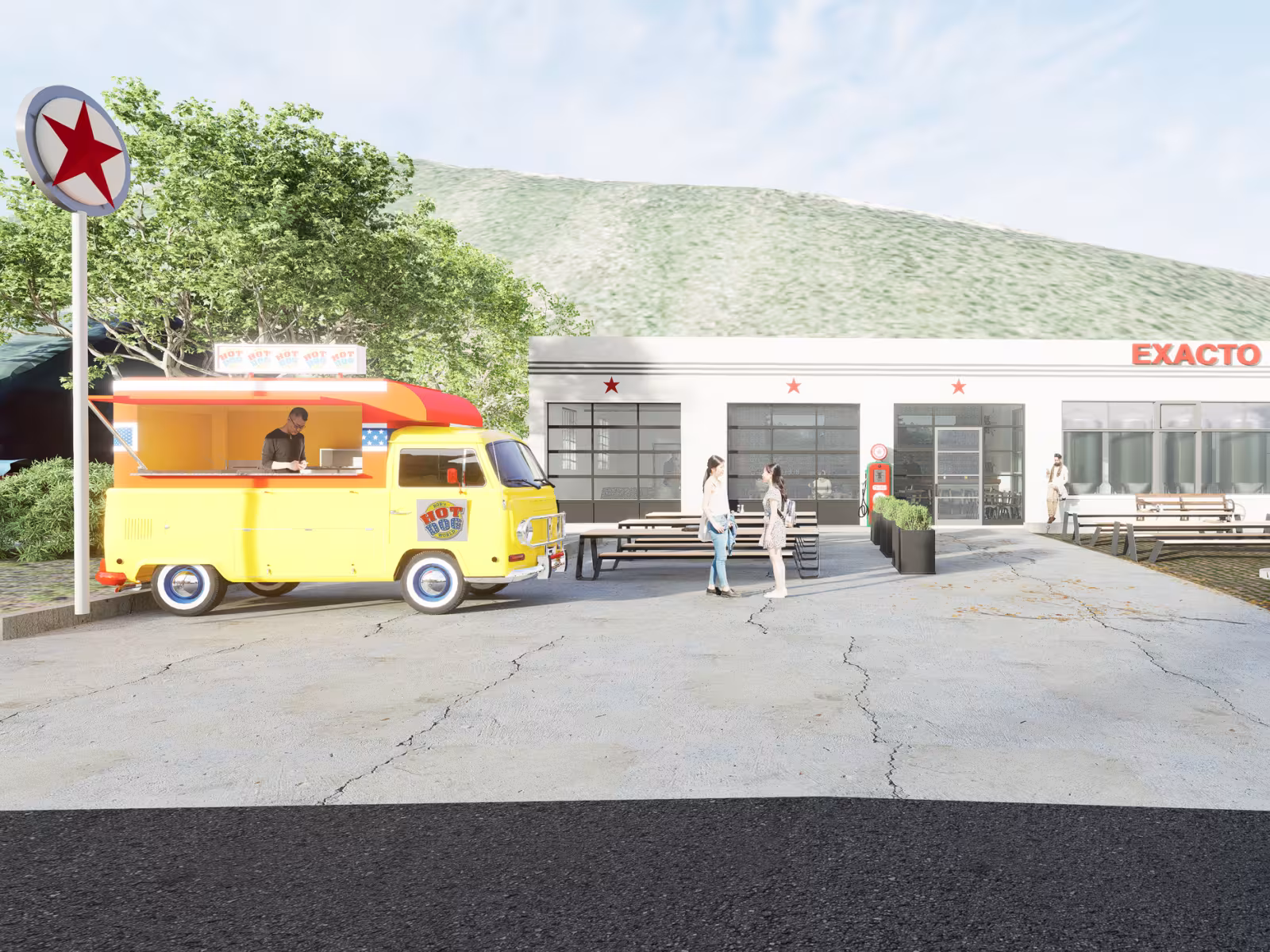 Yellow food truck and people outside a vintage garage with mountains in the background.