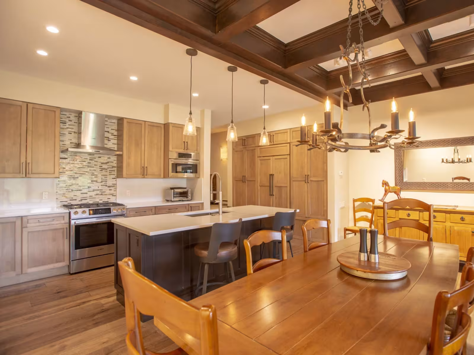 Warm-toned kitchen and dining area with wooden furniture and modern lighting.