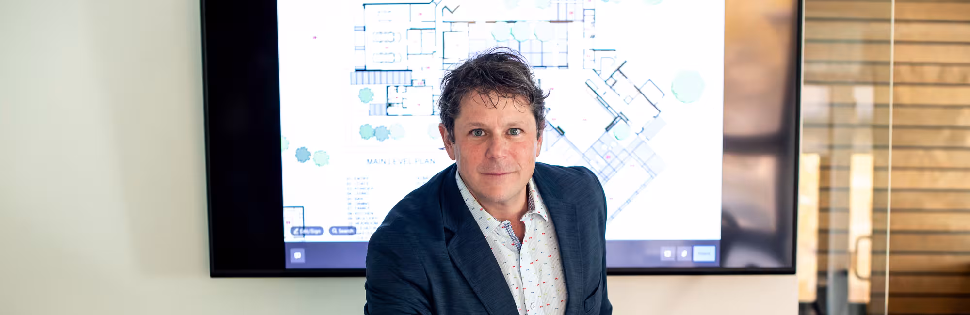 Man reviewing architectural plans in office.